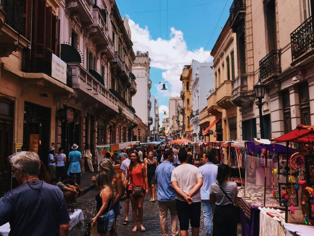 Bustling San Nicolas street market in Buenos Aires with stalls and crowds under a clear sky.