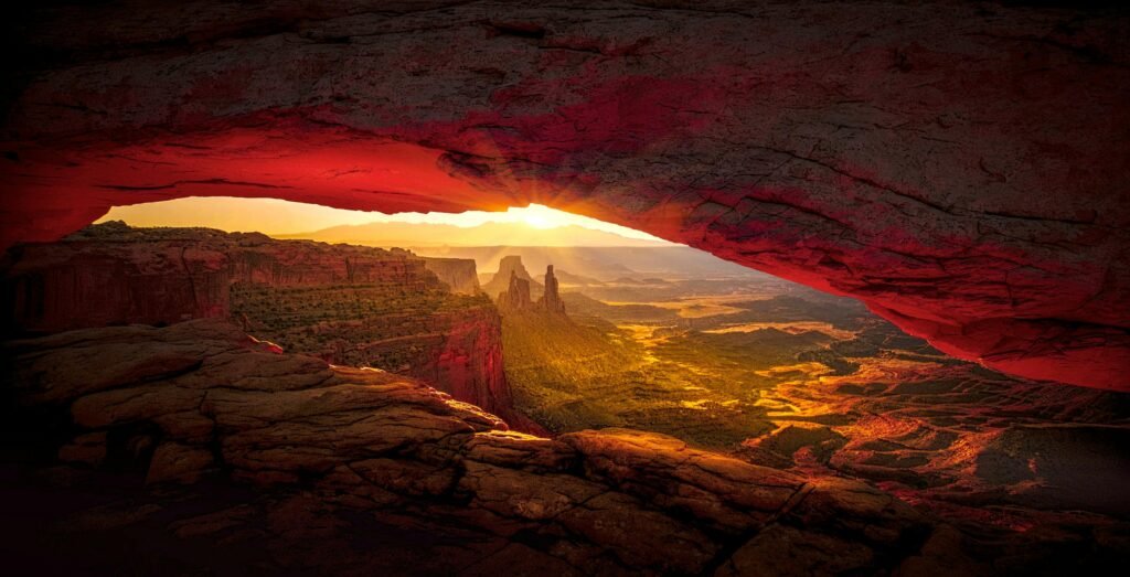 Captivating sunrise view through Mesa Arch in Canyonlands National Park showcasing vibrant desert landscape.