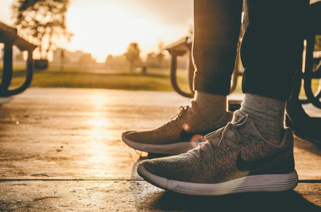 Close-up of sneakers on person standing outdoors at sunrise in a Chicago park.