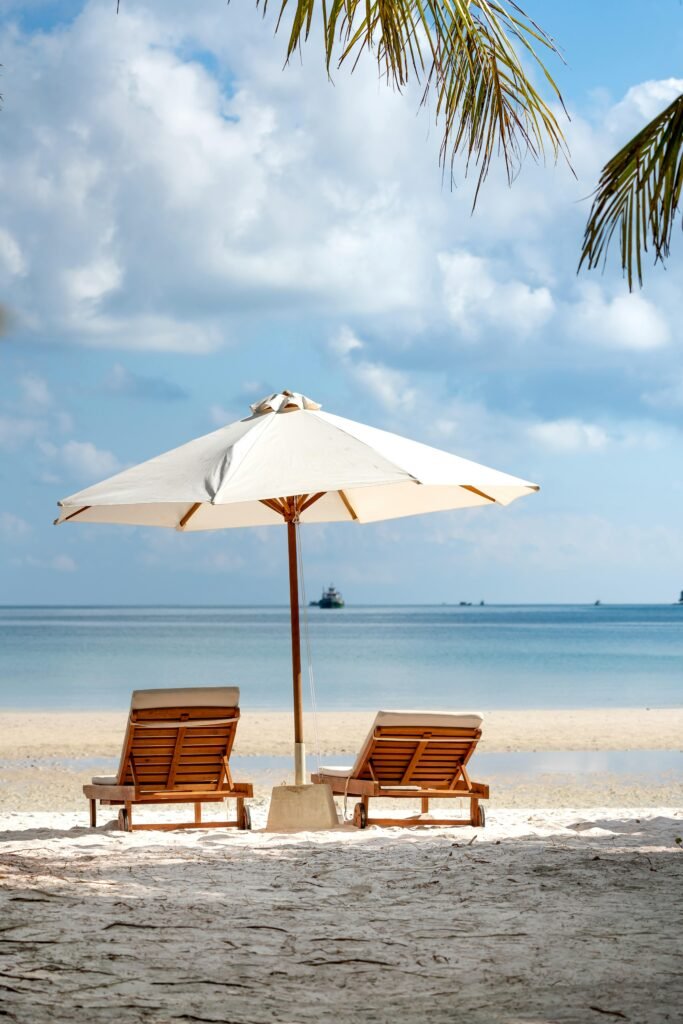 Idyllic beach scene with chairs and umbrella, perfect for a serene vacation setting.