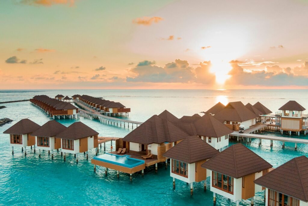 Discover the serenity of overwater bungalows at sunrise, offering a luxurious tropical escape.