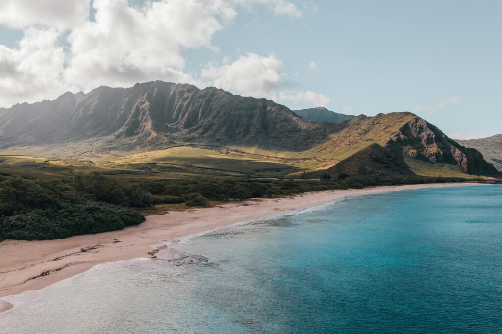 Breathtaking aerial shot of Hawaii's pristine coastline with mountains and ocean.