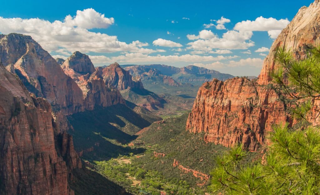 Stunning aerial view of Zion National Park showcasing red cliffs, lush valley, and blue skies.