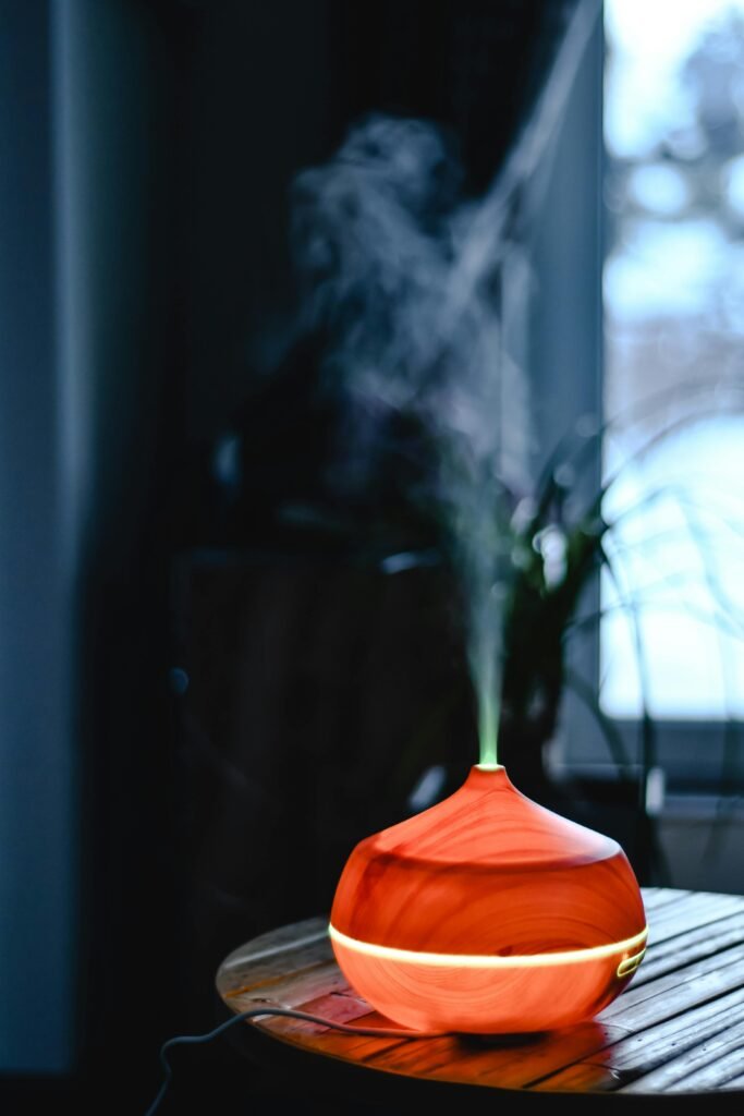 An aromatic wooden diffuser releasing smoke, creating a calm indoor atmosphere near a window.