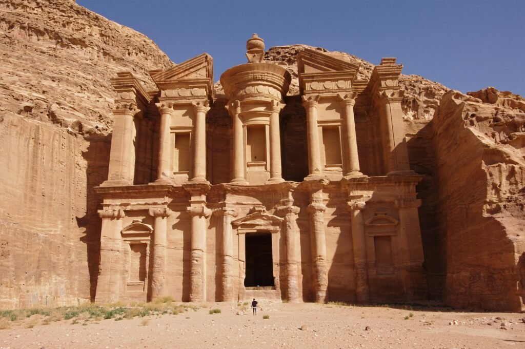 The majestic Al-Deir Monastery stands in Petra, Jordan, showcasing ancient Nabatean architecture carved from rock.