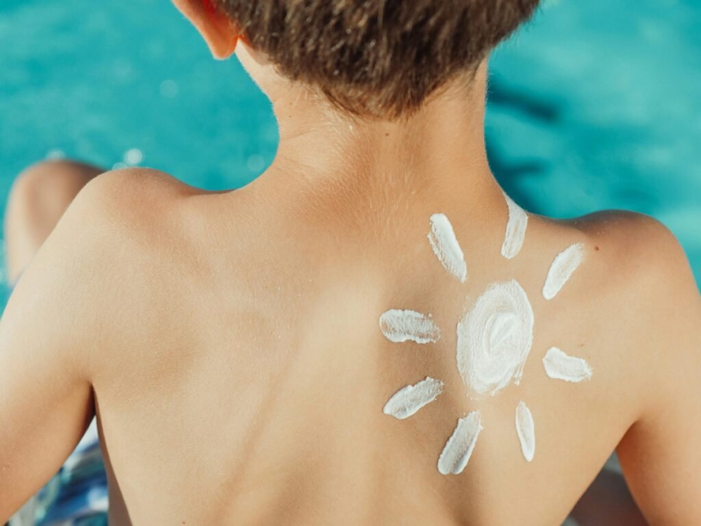 Child's back with sunscreen in sun shape, enjoying a sunny day by the pool.