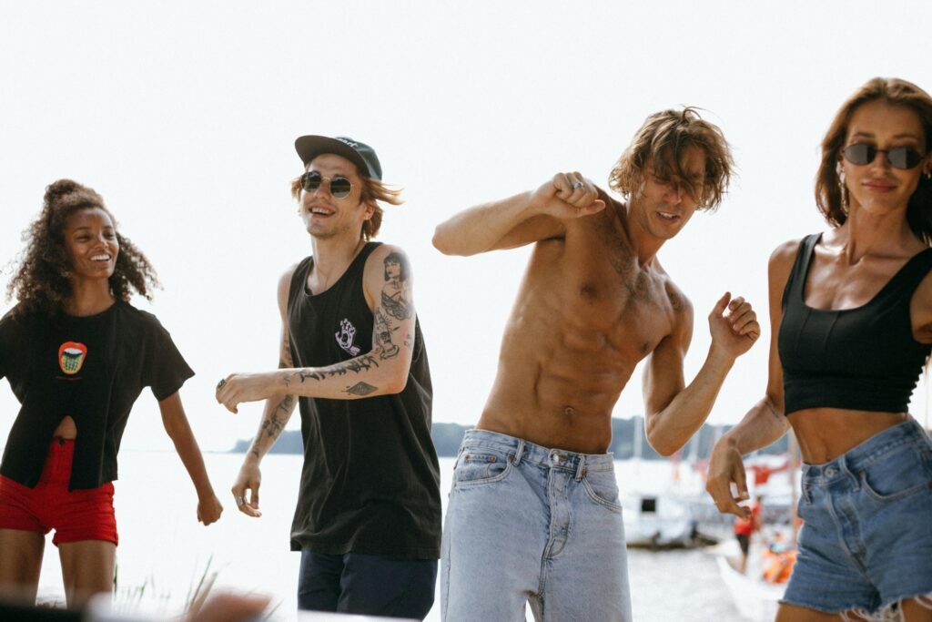 Energetic group of young adults dancing at a lively beachside party.