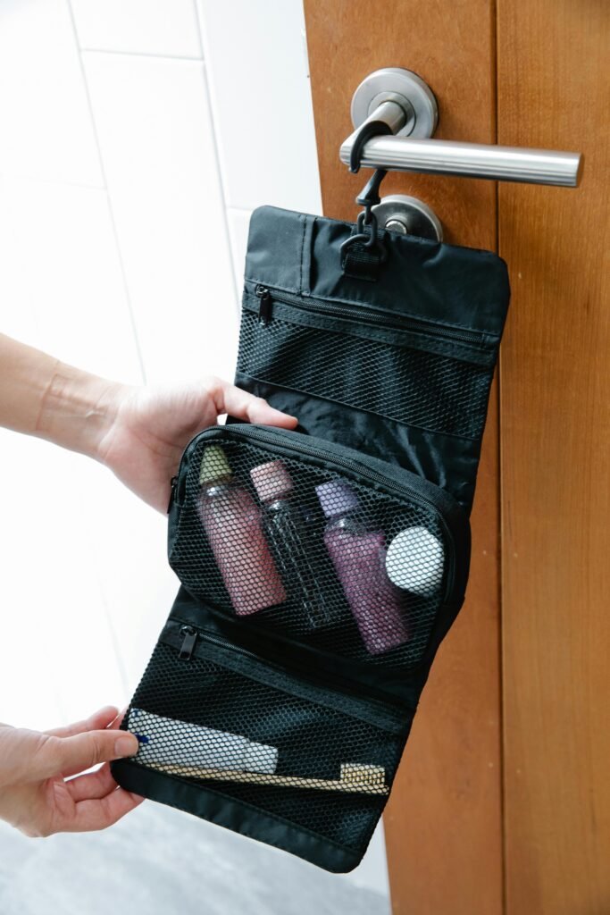 A black toiletry bag with toiletries hanging on a door knob, perfect for travel.