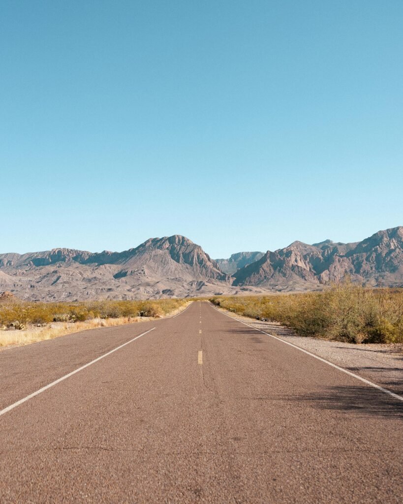 Explore the vast beauty of Big Bend National Park with this stunning road view under a clear blue sky.