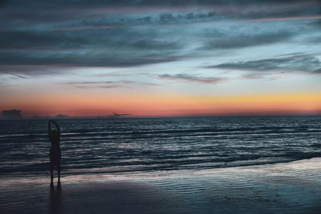 A peaceful sunset scene with a silhouette on Siesta Key Beach, Florida.