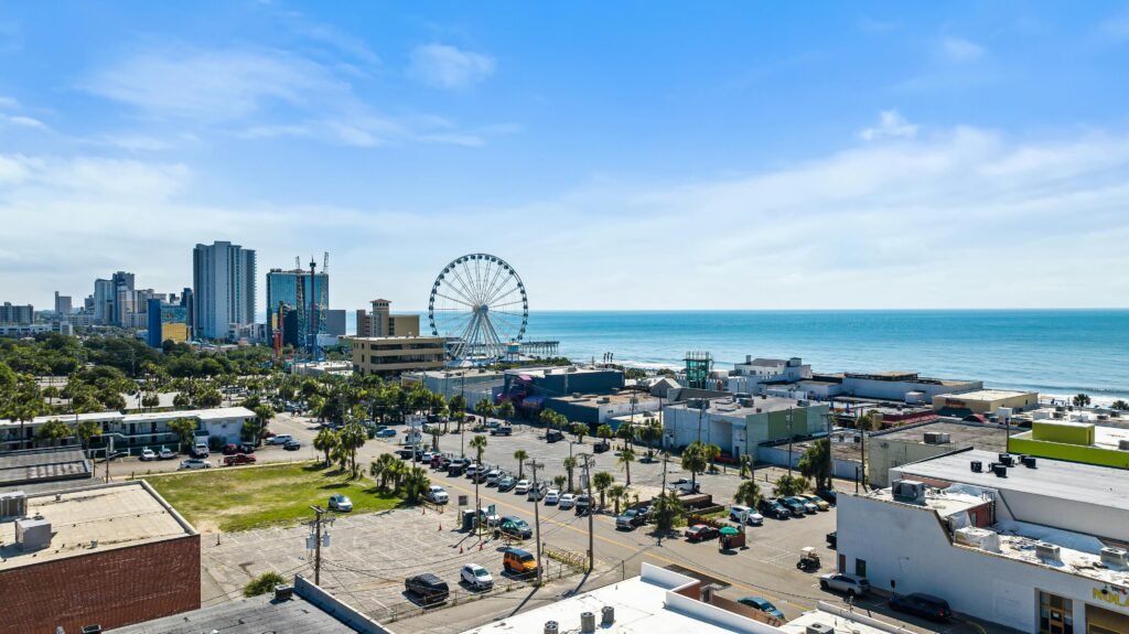 A vibrant aerial view of Myrtle Beach cityscape with Ferris wheel and ocean in the background.