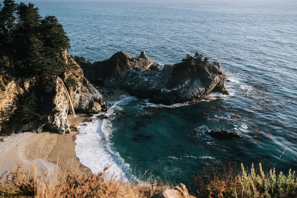 A breathtaking aerial view of Big Sur's rugged coastline with turquoise waters and cliffs.