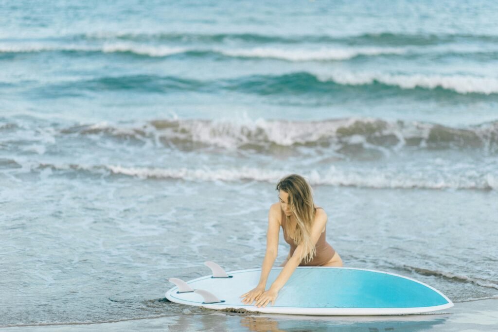 Woman with a surfboard enjoying a sunny day by the ocean, perfect summer vibes.