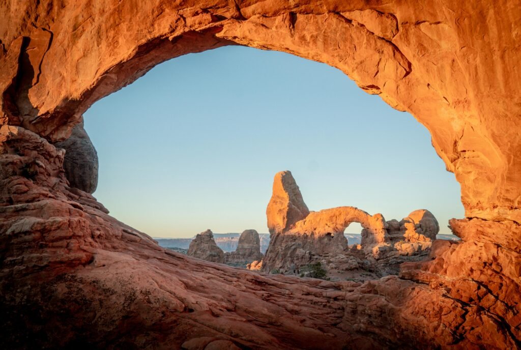 Captivating view of Arches National Park with rock formations glowing under the sunrise.