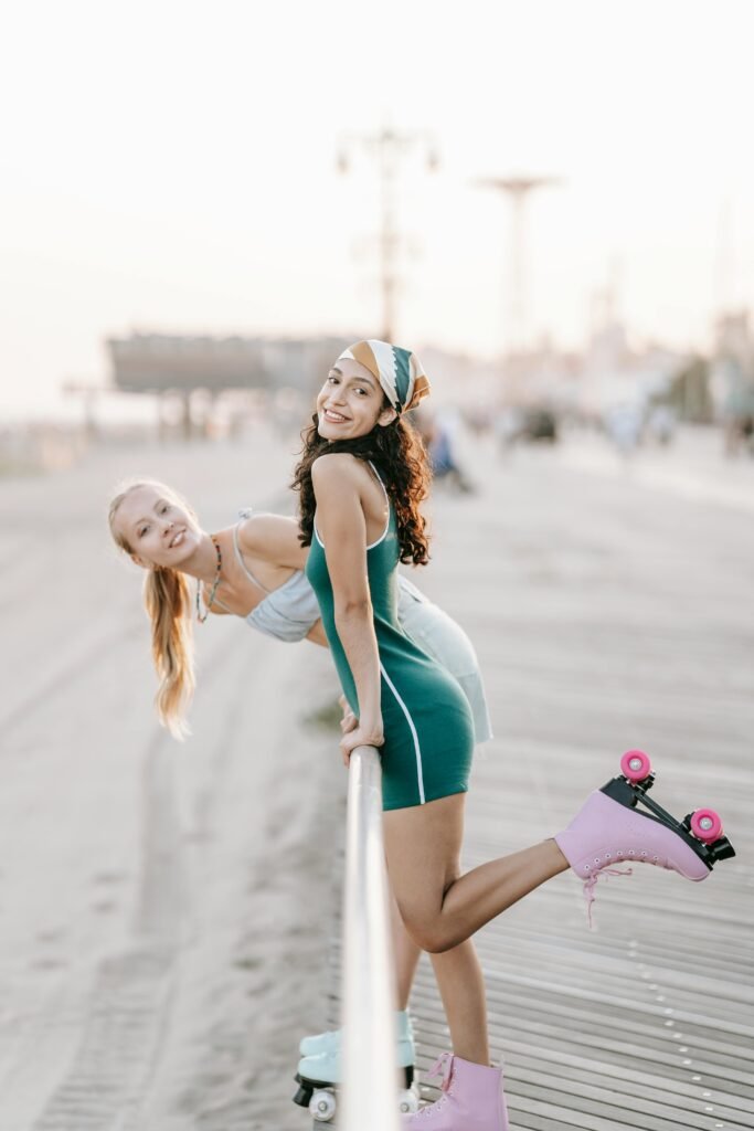 Young women enjoying leisure roller skating by the beach with vibrant emotions.